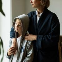 Holder hånd, skulder, barn, voksen, kigger ud af vindue, langt blik, omsorg